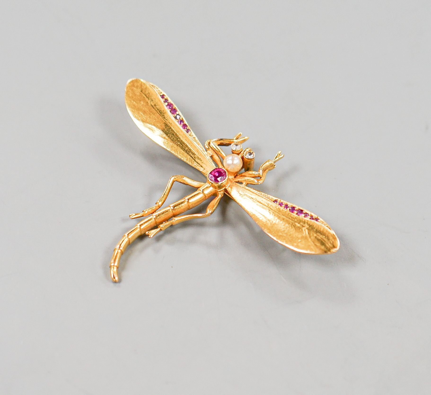A yellow metal, ruby diamond and cultured pearl set dragonfly brooch, diameter 52mm, gross weight 8 grams.